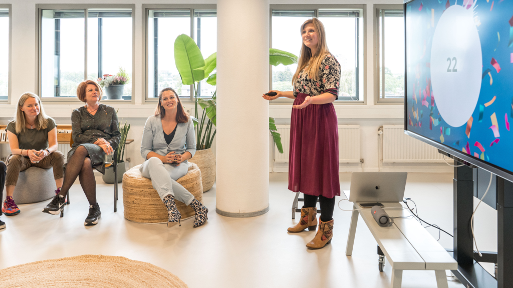 Foto van outfit van facilitator met kleurige blouse en rok